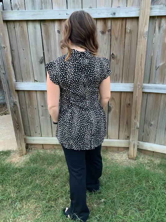 leopard print flutter-sleeved top. It buttons up the back.